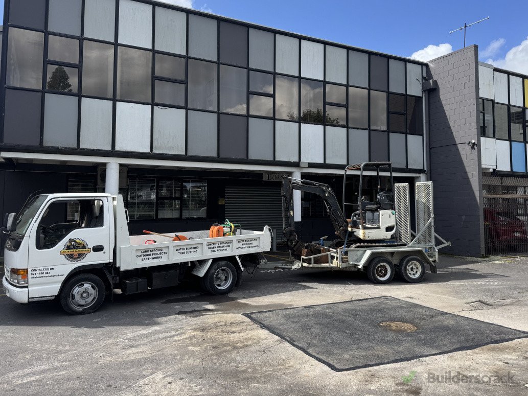 Branded white tipper towing a trailer with a mini-excavator.